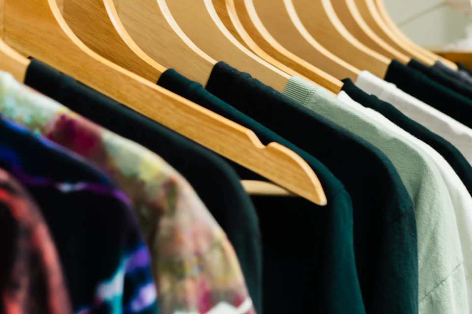 T-Shirts in verschiedenen Farben auf Holzbügeln